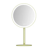 a mirror on a stand with a light green base
