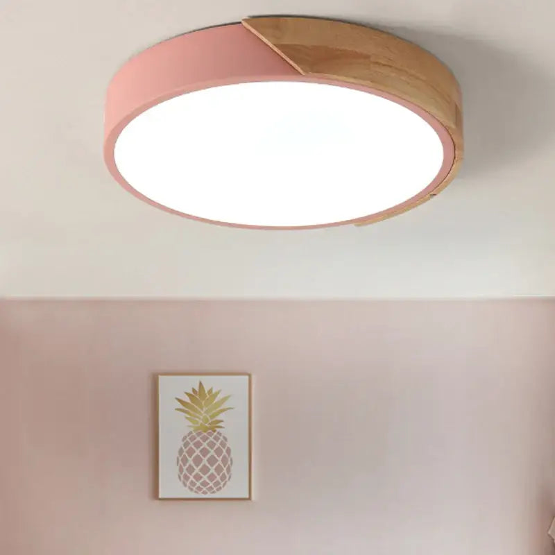 a pink ceiling light with a wooden ceiling