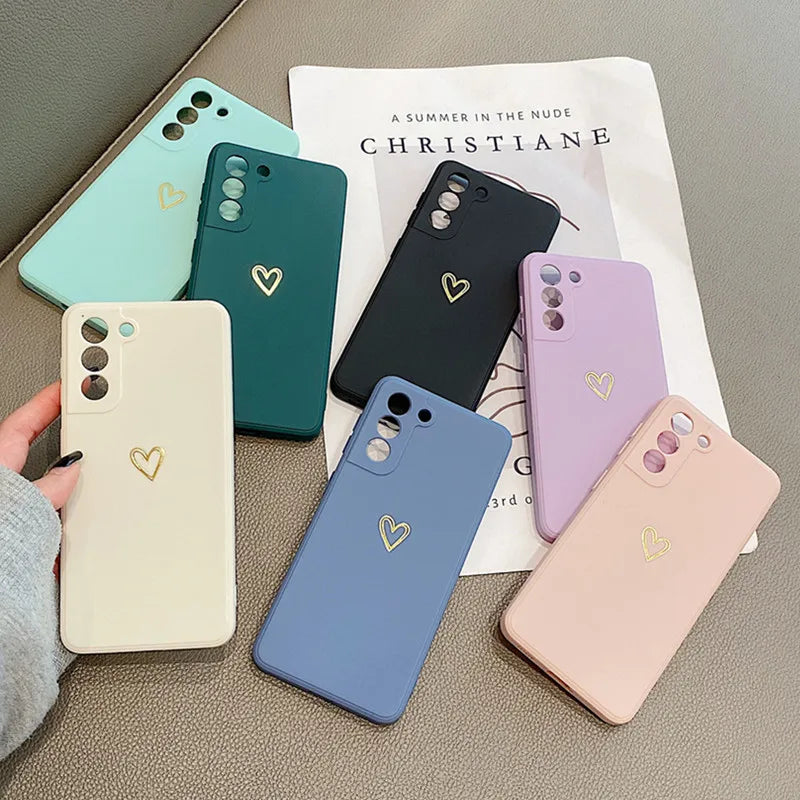 Multiple colorful silicone phone cases with a heart emblem.