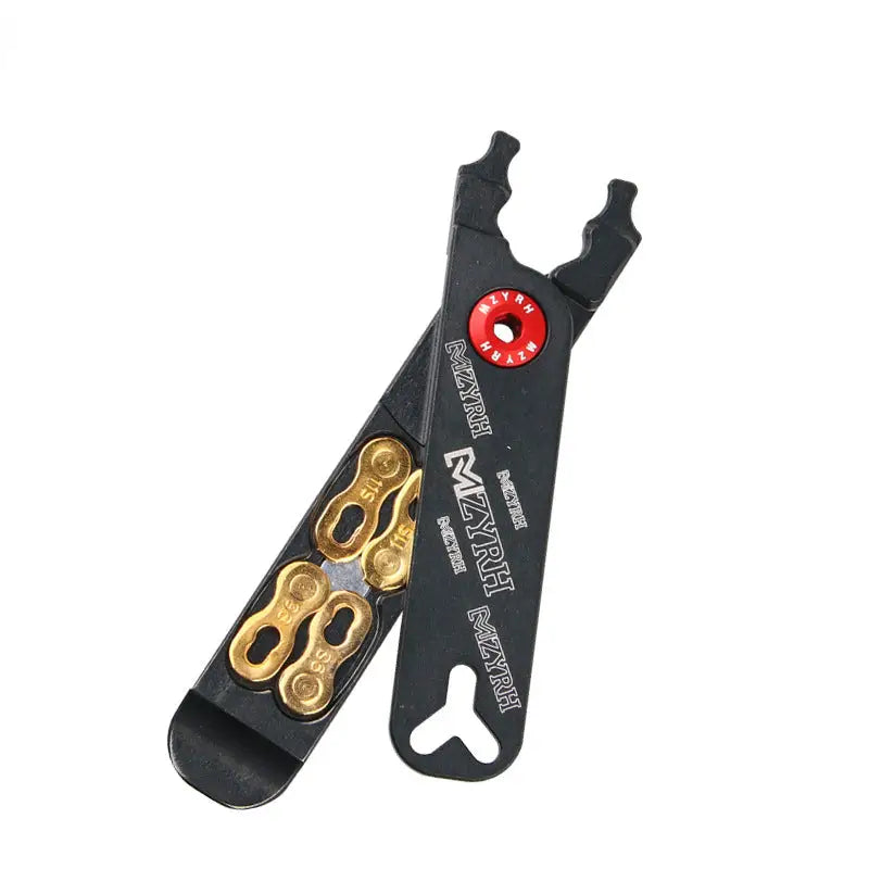 a black and gold pliers with a red button