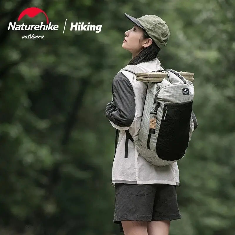 a young boy with a backpack standing on a rock