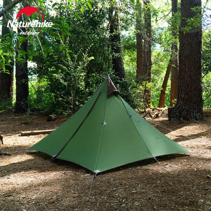 a tent in the woods with trees and grass