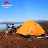 a tent and a bicycle on a hill