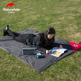 a woman laying on the grass with her laptop