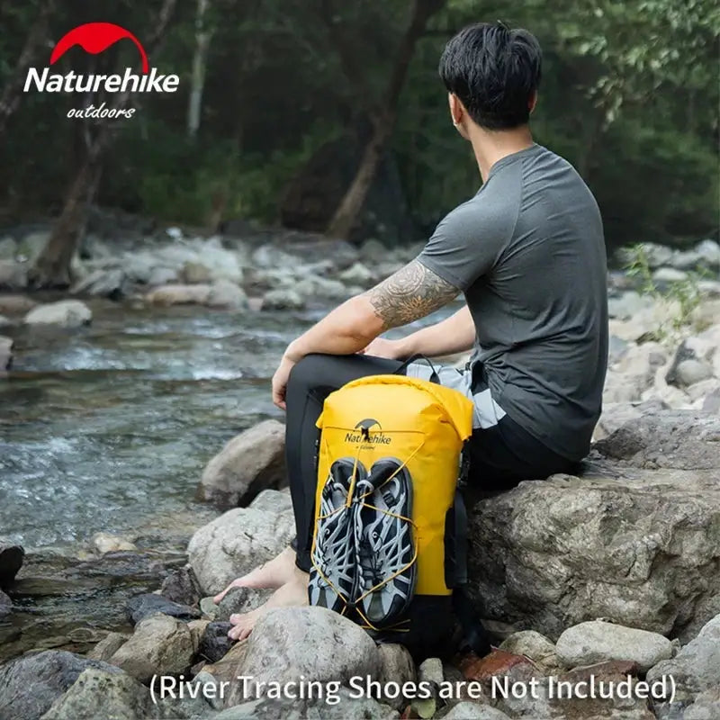 a man sitting on rocks next to a river