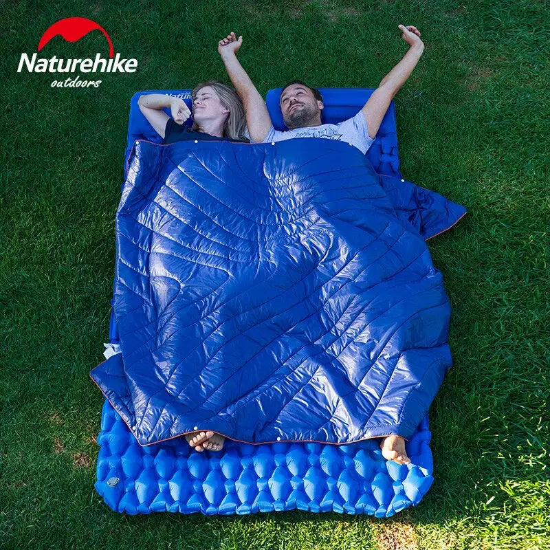 a woman laying on a blue blanket in the grass