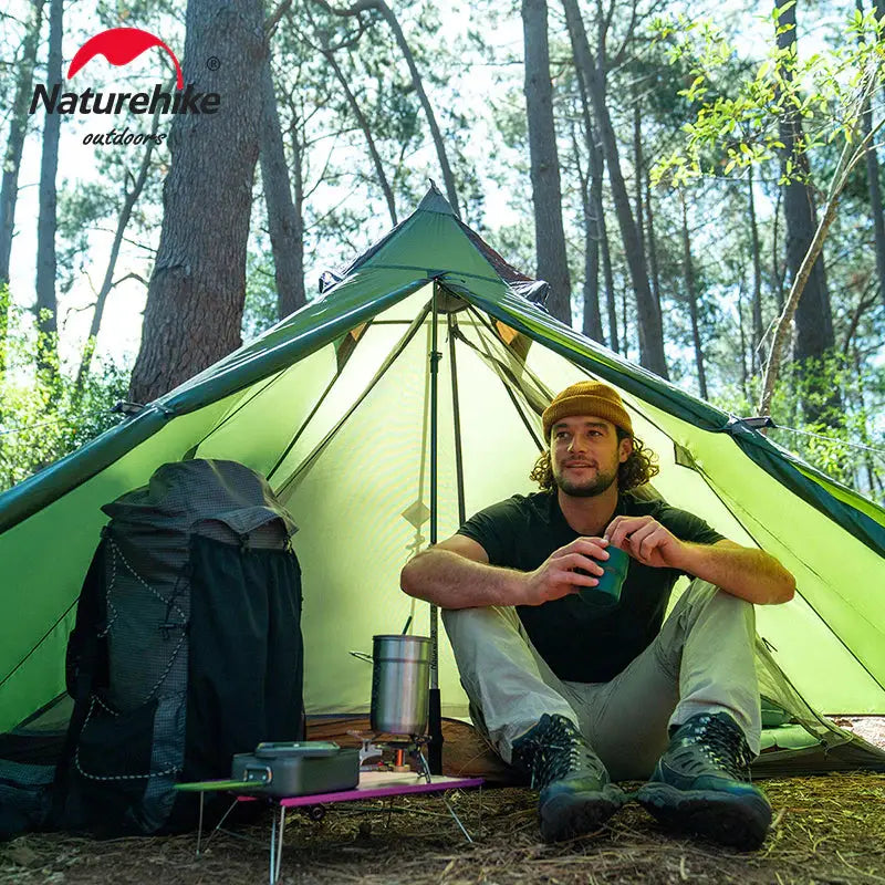 a man sitting in front of a tent