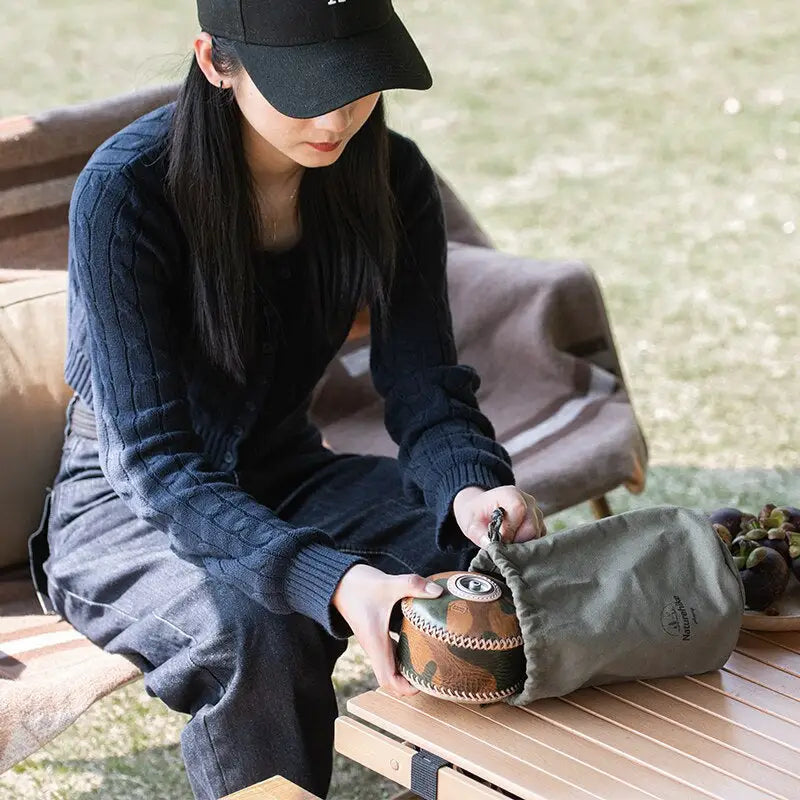 a woman sitting on a bench with a hat and a bag