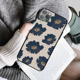 a woman holding a phone case with a blue flower pattern