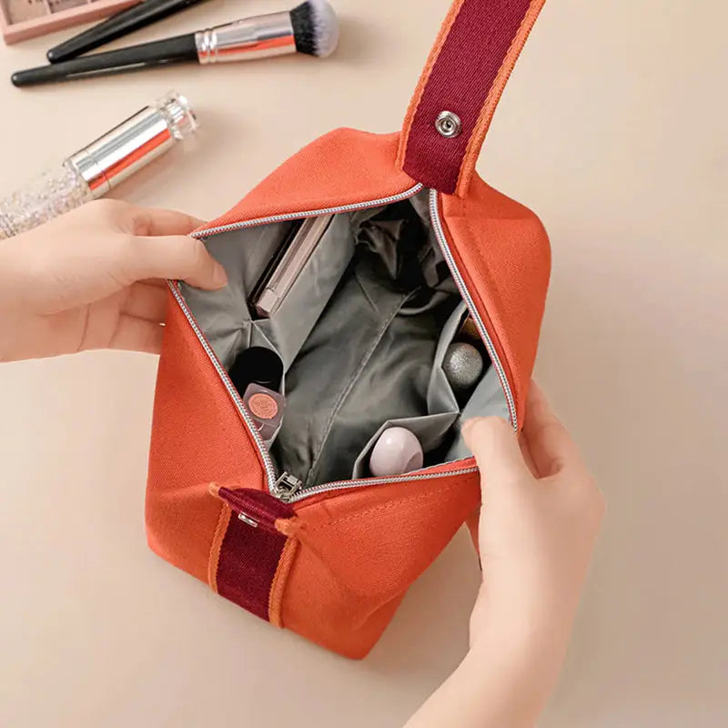 a woman holding a small orange purse bag