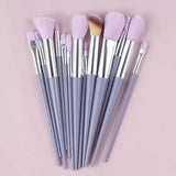 a set of makeup brushes on a pink background