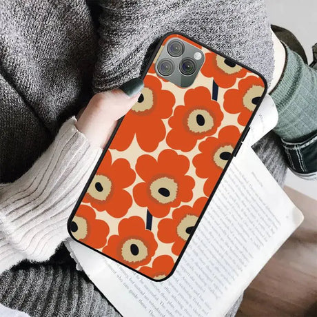 a woman holding a book and a phone case