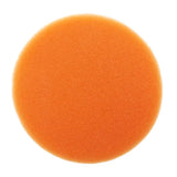 a round orange sponge on a white background