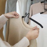 a woman is holding a hanger in front of her clothes