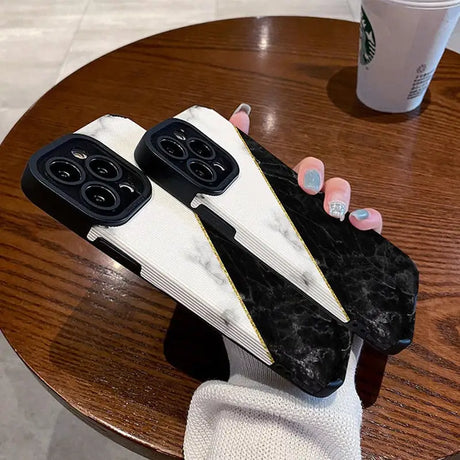 a pair of black marble phone cases on a table