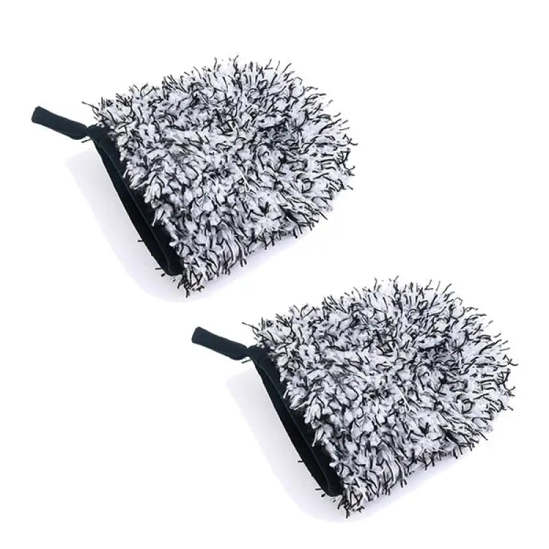 pair of black and white fuzzy mitts on a white surface