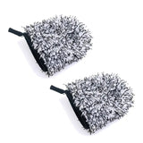 pair of black and white fuzzy mitts on a white surface