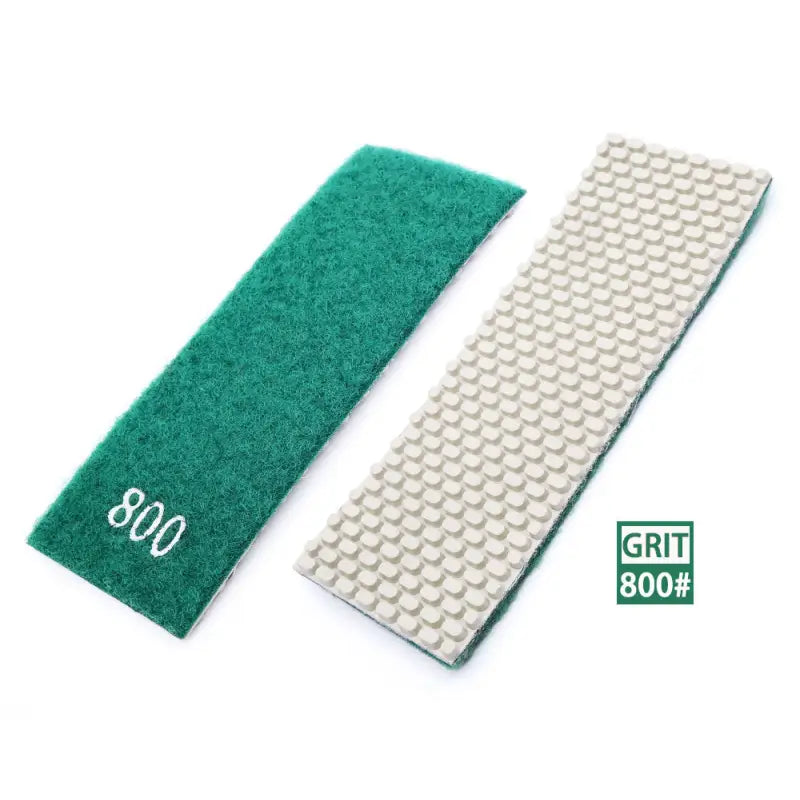 a close up of a pair of green and white grit pads