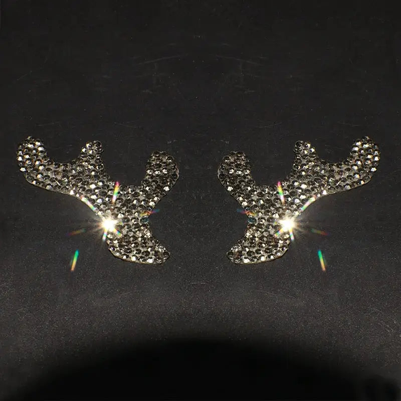 a pair of earrings with a deer head