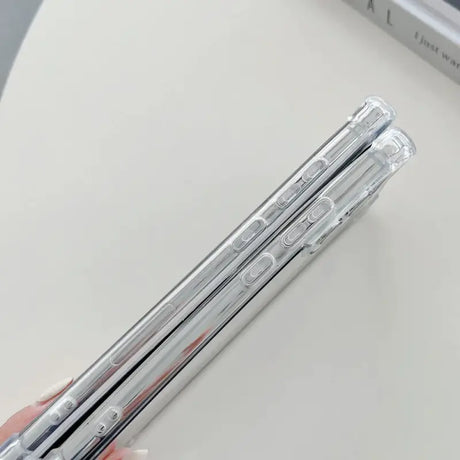 Someone holding a pair of silver metal pens on a table