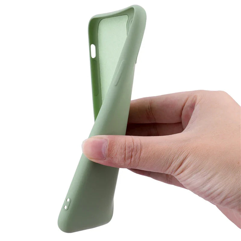 Pale green silicone smartphone case held by a hand.