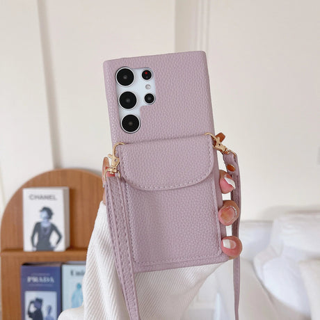 Pale pink smartphone case with a built-in wallet pocket and decorative strap.