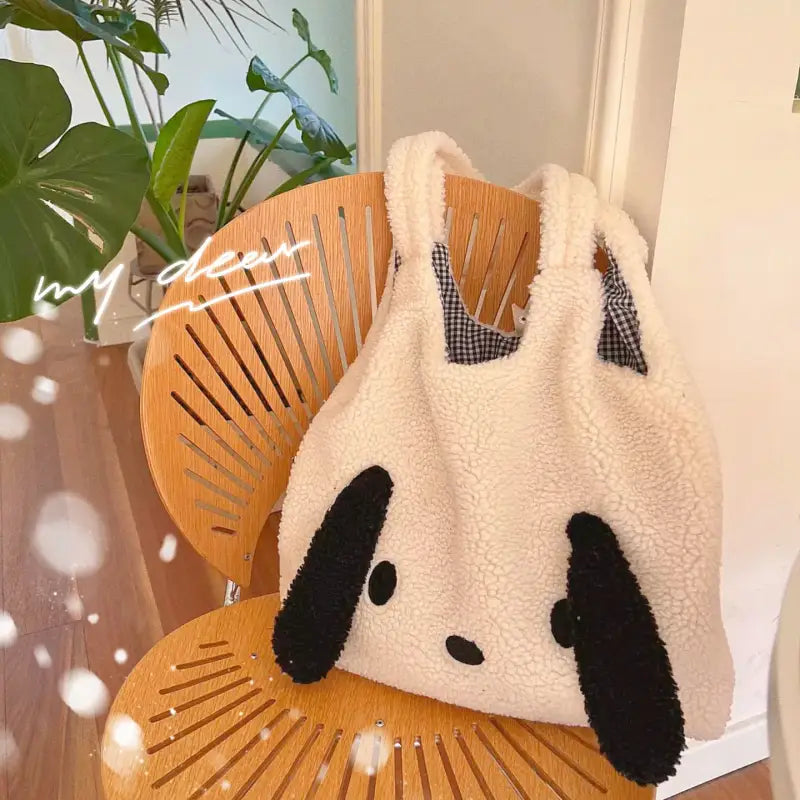 a panda bear bag sitting on a chair