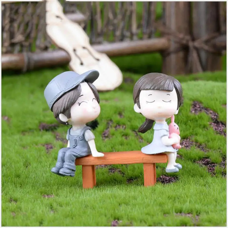 a couple sitting on a bench in the grass