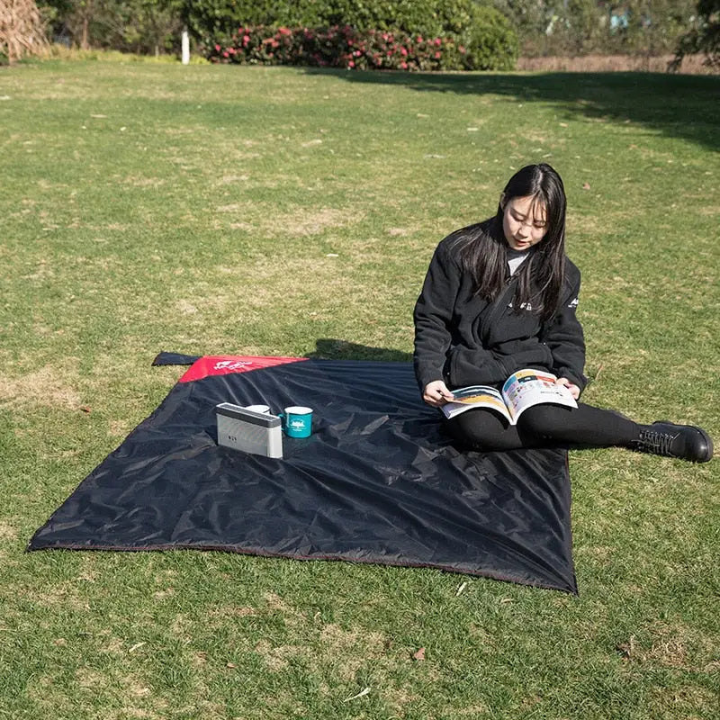 a woman sitting on the grass reading a book