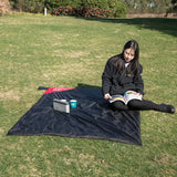 a woman sitting on the grass reading a book