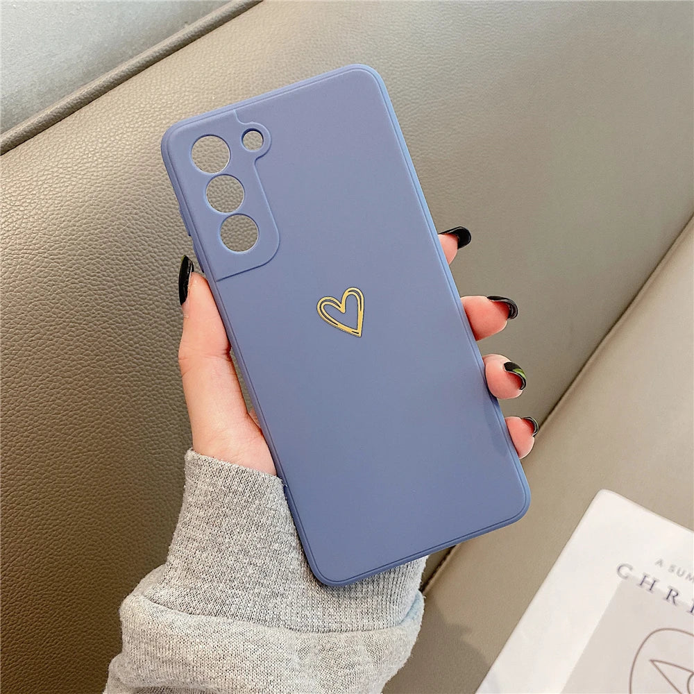Periwinkle blue smartphone case with a gold heart emblem and camera cutouts.