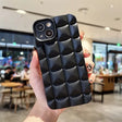 A person holding a black phone case