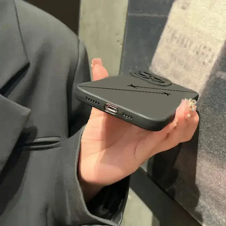 A person holding a black phone in their hand