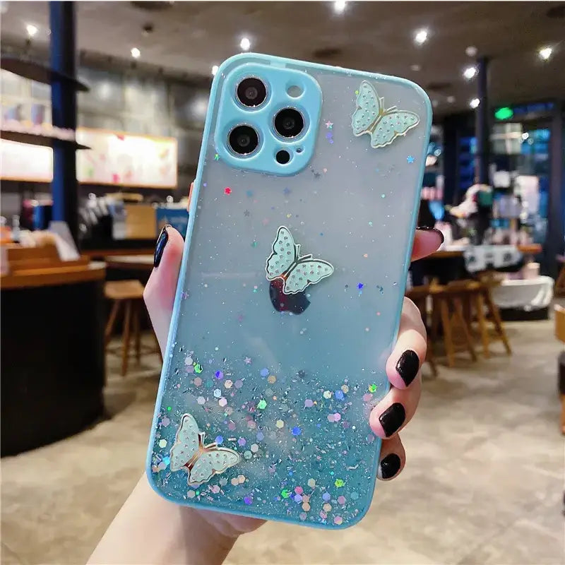 A person holding a blue case with glitter butterflies on it