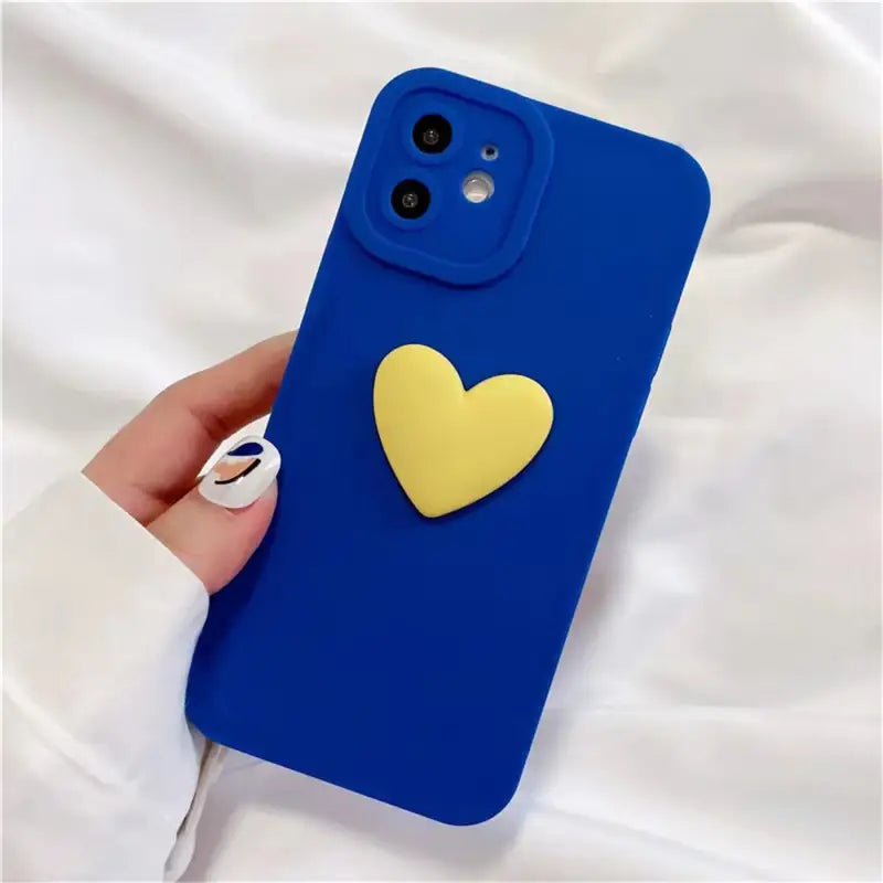 a person holding a blue phone case with a heart on it