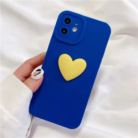 A person holding a blue phone case with a heart on it