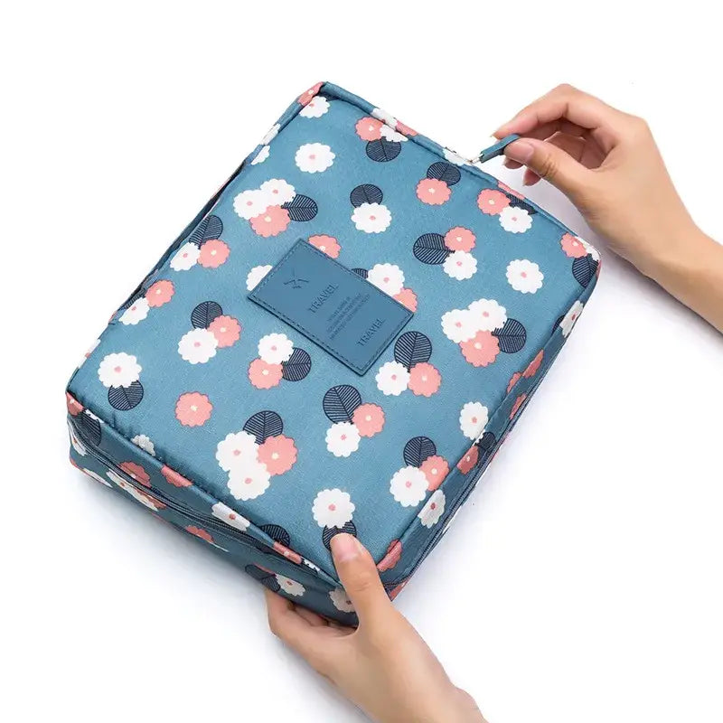 a person holding a blue and pink floral print toilet bag