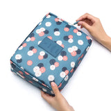 a person holding a blue and pink floral print toilet bag