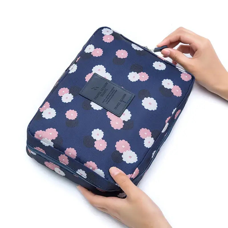 a person holding a blue and pink floral print toilet bag