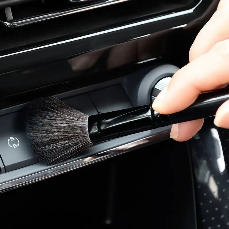 a person is using a brush to clean the interior of a car