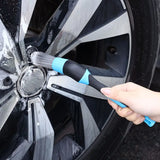 a person using a brush to clean the rim of a car