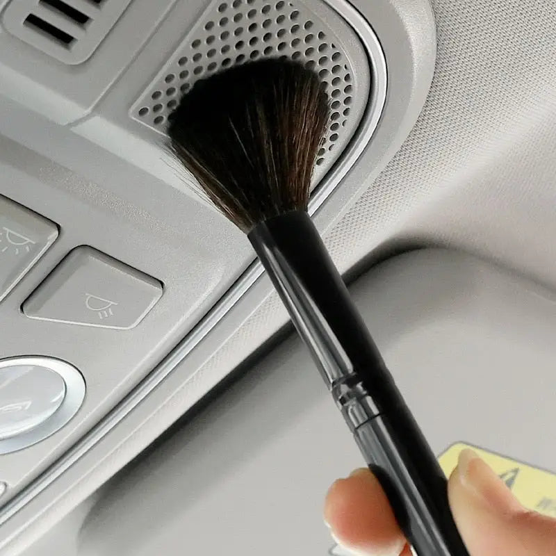 a person using a brush to clean the dashboard