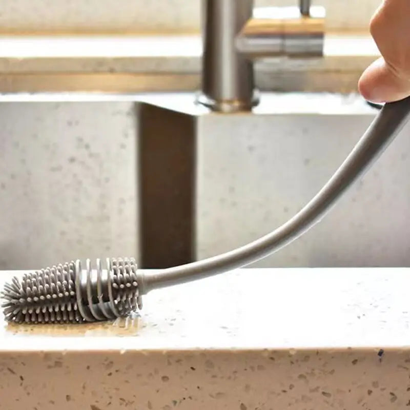 a person using a metal brush to clean a sink