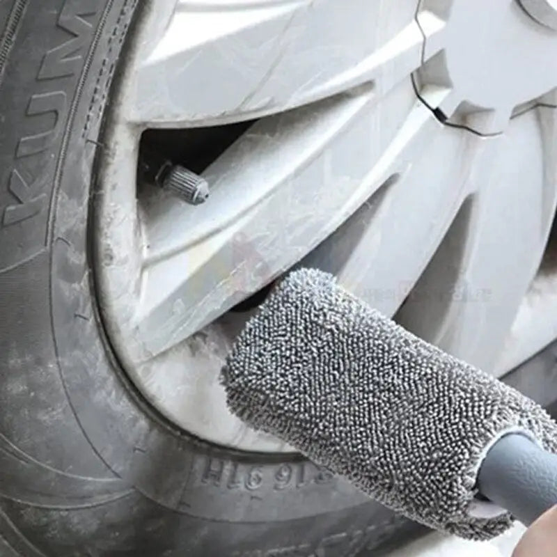 a person using a brush to clean a tire