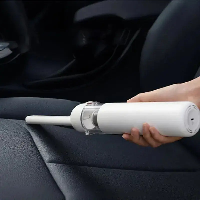 a person using a car vacuum to clean the interior