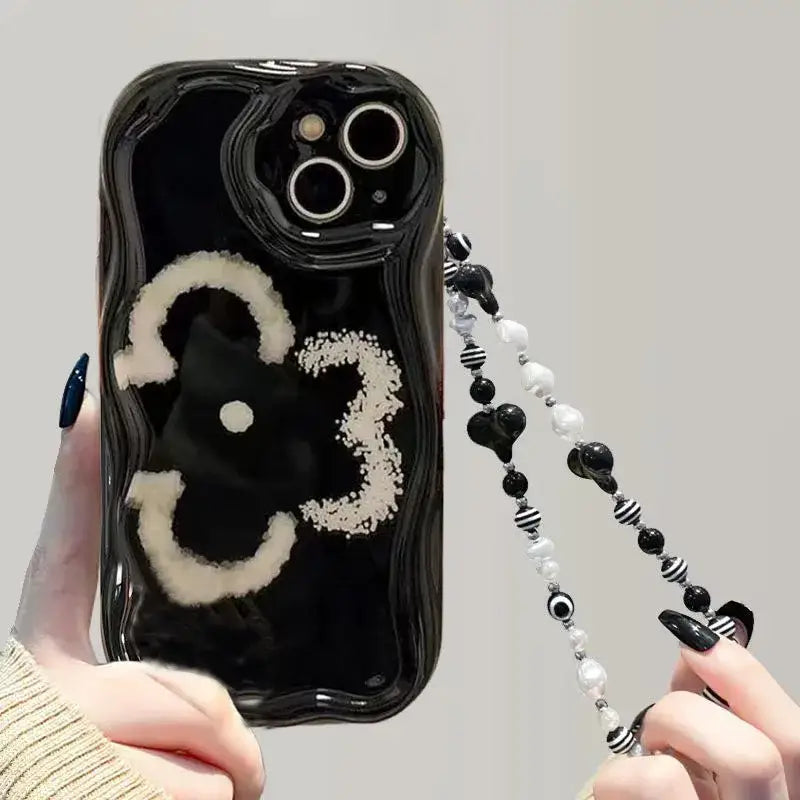 a person holding a cell case with a black and white design