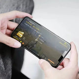 a person holding a cell phone with a screen showing a video game