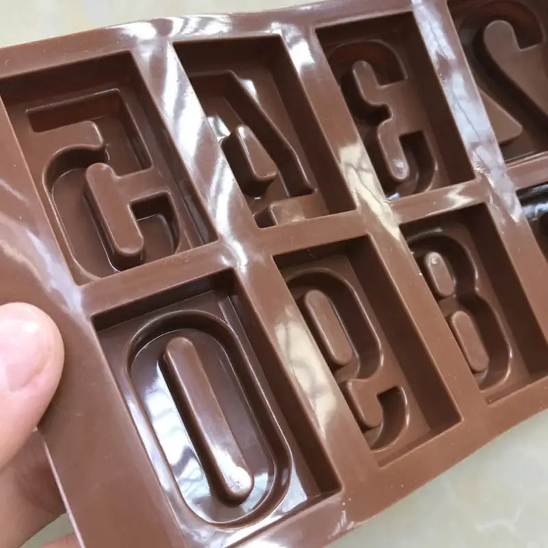 a person holding a chocolate bar with the letters on it