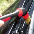 a person cleaning a car with a brush