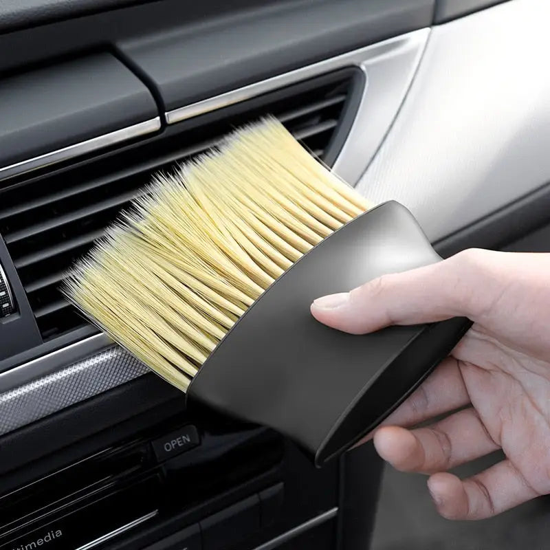 a person cleaning a car with a brush